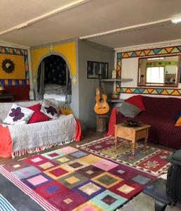 伊尔弗勒科姆Secret Woodland Hideaway for two的一间卧室配有一张床和吉他
