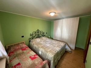 波斯科Rosa Mountain Lake Iseo Hospitality的一间卧室设有两张床,拥有绿色的墙壁