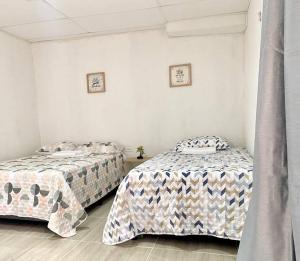 里奥阿查Apto #6 hermoso y amplio的白色墙壁客房的两张床