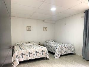 里奥阿查Apto #6 hermoso y amplio的白色墙壁客房的两张床