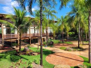 博尼图阿瓜斯德博尼托旅馆的一座棕榈树度假村,位于一座建筑前