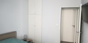 阿克斯莱泰尔姆Appartement T2 45 m² en centre-ville的卧室设有白色墙壁、一张床和一个衣柜。