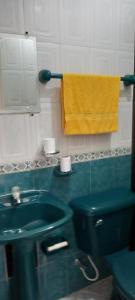 卡利Helena Hostel的浴室设有绿色水槽和黄色毛巾