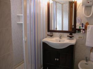 卡诺萨迪普利亚肯纽西恩酒店的一间带水槽、镜子和淋浴的浴室