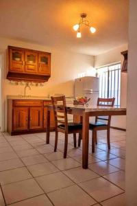 华雷斯城Departamento con Amplia Terraza en Excelente Zona的厨房配有桌椅和冰箱。
