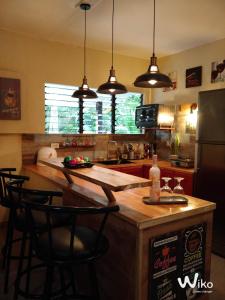 SamboanHouse Rental Banaba Tree的厨房配有带椅子的柜台和冰箱。