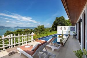 攀瓦海滩Soul Villas by The Beach - Phuket的一个带桌椅的阳台和一个游泳池