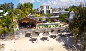蒙舒瓦西Wonders Beach Boutique Hotel的享有带椅子和遮阳伞的度假村的空中景致