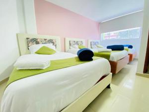 波哥大Hotel Calantha的粉红色和白色的客房内的两张床
