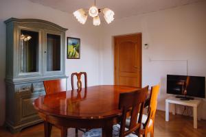 埃伦豪森Zimmer & Appartements in der Gamlitzerstrasse的一间带木桌和电视的用餐室