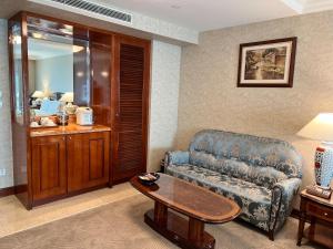 台北台北长荣桂冠酒店的客厅配有沙发和桌子