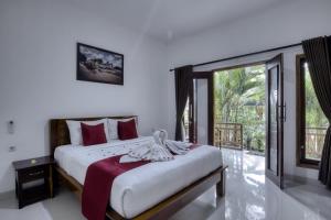 珀尼达岛Indah Guest House Nusa Penida的一间卧室设有一张大床和一个大窗户