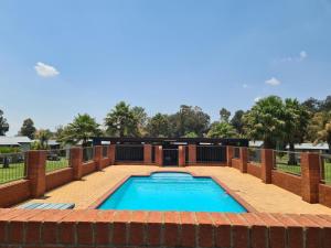 纽卡斯尔Snips Accommodation的一个带砖砌庭院和泳池景的游泳池