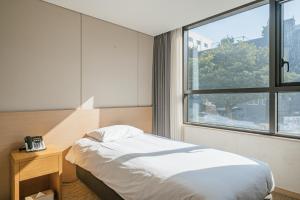西归浦市Hotel Zinc的酒店客房设有床和窗户。
