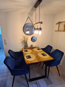 青斯特Möwenstübchen的一张带蓝色椅子和镜子的餐桌