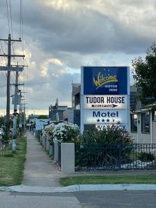 谢珀顿SHEPPARTON MOTOR INN Tudor House Motel的建筑物前的拖 ⁇ 房屋标志