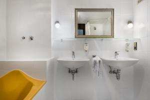 科尔恩塔尔-明欣根诺夫斯特罗告酒店的白色的浴室设有两个盥洗盆和镜子