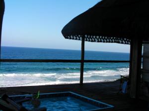 伊尼扬巴内Mozambique,Inhambane,Barra -Entire Beach House的海滩上的游泳池,配有遮阳伞