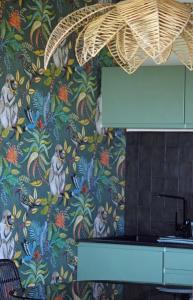 圣皮埃尔Kaz C2C - Une maison Balinaise avec jacuzzi的厨房设有一面带花卉壁纸的墙壁