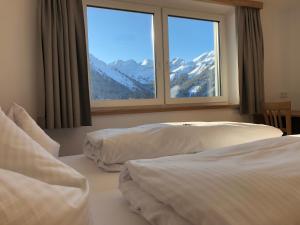 贝旺Gasthof Bergblick的配有大窗户的酒店客房内的两张床