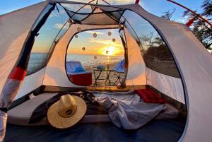 卡胡卢伊Epic Maui Car Camping的海滩上的帐篷,上面有帽子