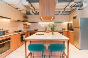 香港Weave Suites - Central West的一个带2把蓝色椅子的大岛厨房