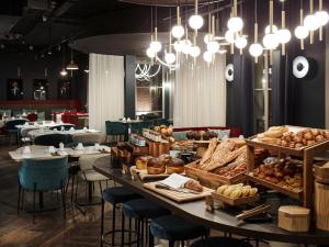 勒图凯-巴黎普拉日Mercure Hôtel Le Touquet的面包店,桌上放有面包和糕点