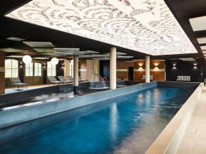 勒图凯-巴黎普拉日Mercure Hôtel Le Touquet的一座带天花板的酒店游泳池