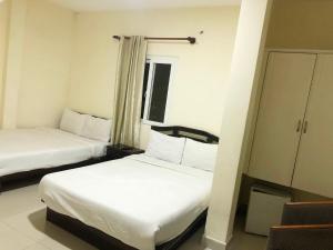 大叻芳香旅馆 的酒店客房设有两张床和橱柜。