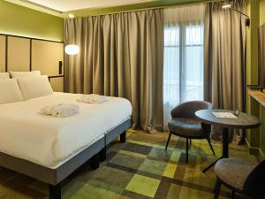 勒图凯-巴黎普拉日Mercure Hôtel Le Touquet的酒店客房配有一张床铺和一张桌子。