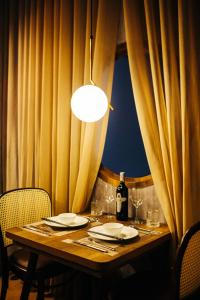 河内Apastar Luxury - Vinhomes Smart City的一张木桌,配有一瓶葡萄酒和玻璃杯