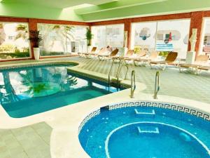 马贝拉Casa Hibiscus Marbella的游泳池,酒店内设有椅子和游泳池