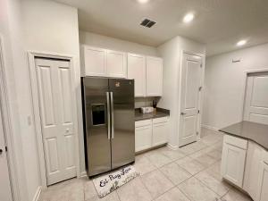 达文波特Grand Family Deluxe 4BR House near Disney Parks的厨房配有不锈钢冰箱和白色橱柜