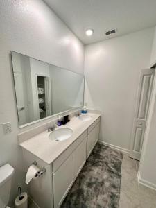 达文波特Grand Family Deluxe 4BR House near Disney Parks的一间带两个盥洗盆和大镜子的浴室