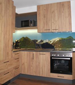 贝旺Gasthof Bergblick的厨房配有木制橱柜和炉灶烤箱。