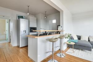 布洛涅-比扬古New ! Cosy Apt, ideal couple centre de Boulogne的厨房以及带柜台和冰箱的起居室。