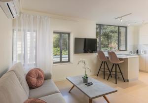 耶路撒冷The Pearl of Nachlaot Apartments的客厅配有沙发和桌子