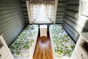 NuorgamBeautiful riverside cottage with sauna的小房间设有两张床和窗户