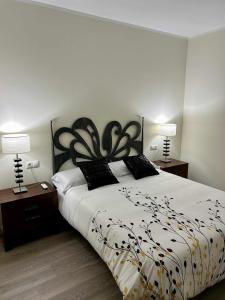 莱里达Casa Rural Namasté con SPA的一间卧室配有一张带两盏灯的黑白床。