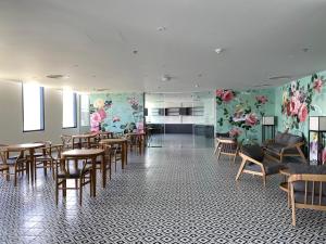 金兰市Seaview Arena Cam Ranh Nha Trang hotel near the airport的用餐室的墙壁上摆放着桌椅和鲜花
