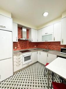 帕德隆Casa dos Cantares的厨房配有白色橱柜和黑白瓷砖地板。