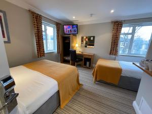 泰晤士河畔里士满Shandon Hotel的酒店客房配有两张床和一张书桌