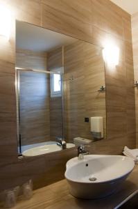 乐托卡亚奥林波斯酒店的浴室配有盥洗盆、镜子和浴缸