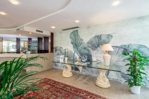 比比翁Hotel Jasminum的客厅配有玻璃桌和壁画