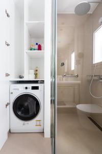 阿雷西费Rooms & Suites Loft 2G Deluxe Edition Arrecife的带淋浴的浴室内的洗衣机