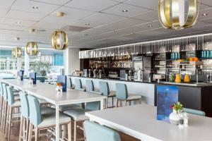 乌得勒支乌得勒支NH酒店的一间带桌椅的餐厅和一间酒吧