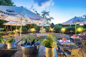 莱比锡温多夫西佳酒店的一个带桌子和遮阳伞的庭院和一个喷泉