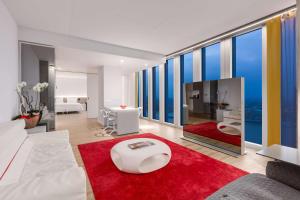 鹿特丹恩豪鹿特丹酒店的客厅配有白色沙发和红色地毯。