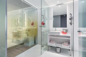 鹿特丹恩豪鹿特丹酒店的一间带玻璃淋浴和水槽的浴室