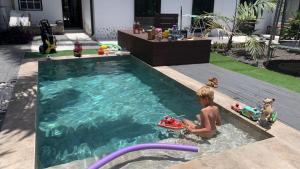 洛斯·亚诺斯·德·阿里丹Villa Mamita的一名男孩在游泳池玩玩具